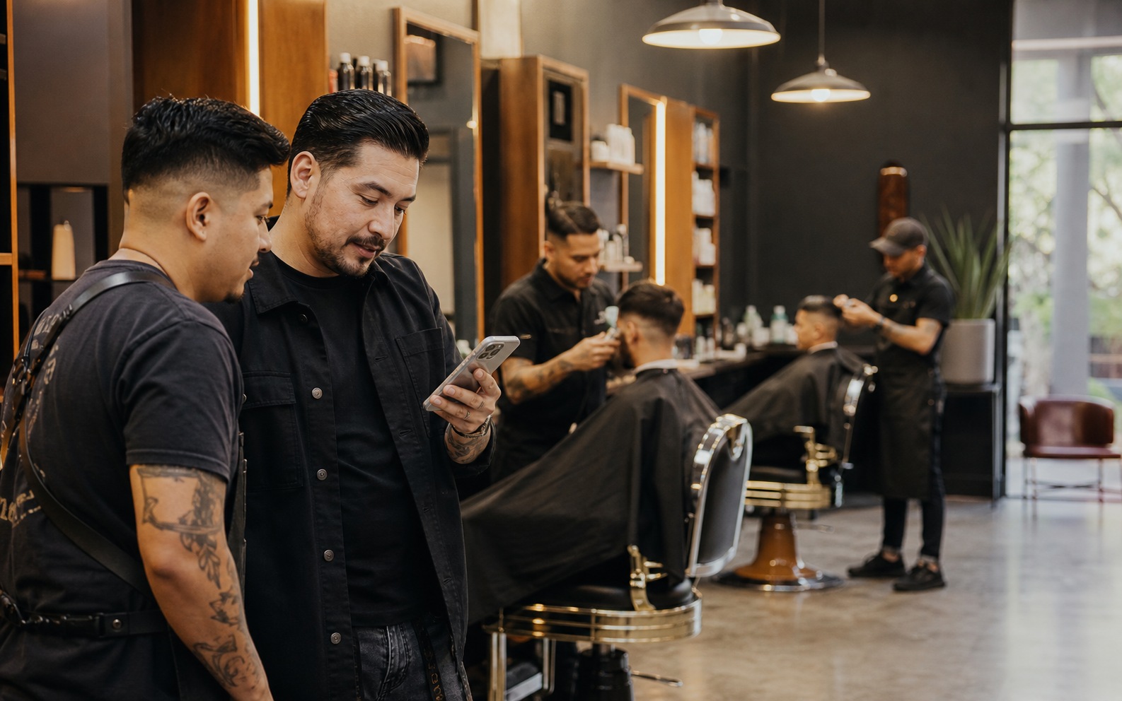 Emprendedor consulta la operación en su teléfono dentro de una barbería